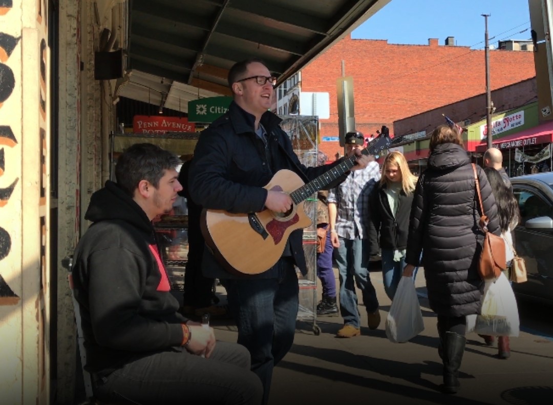 Josh performing on the street in Pittsburgh's Strip District